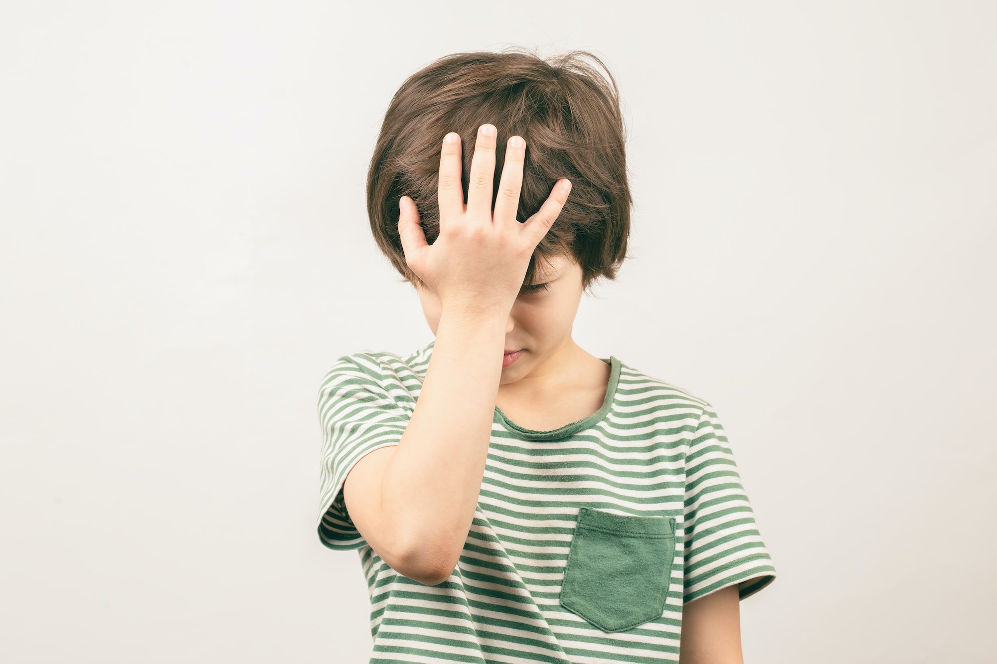 Boy placing hand on head. Face palm gesture