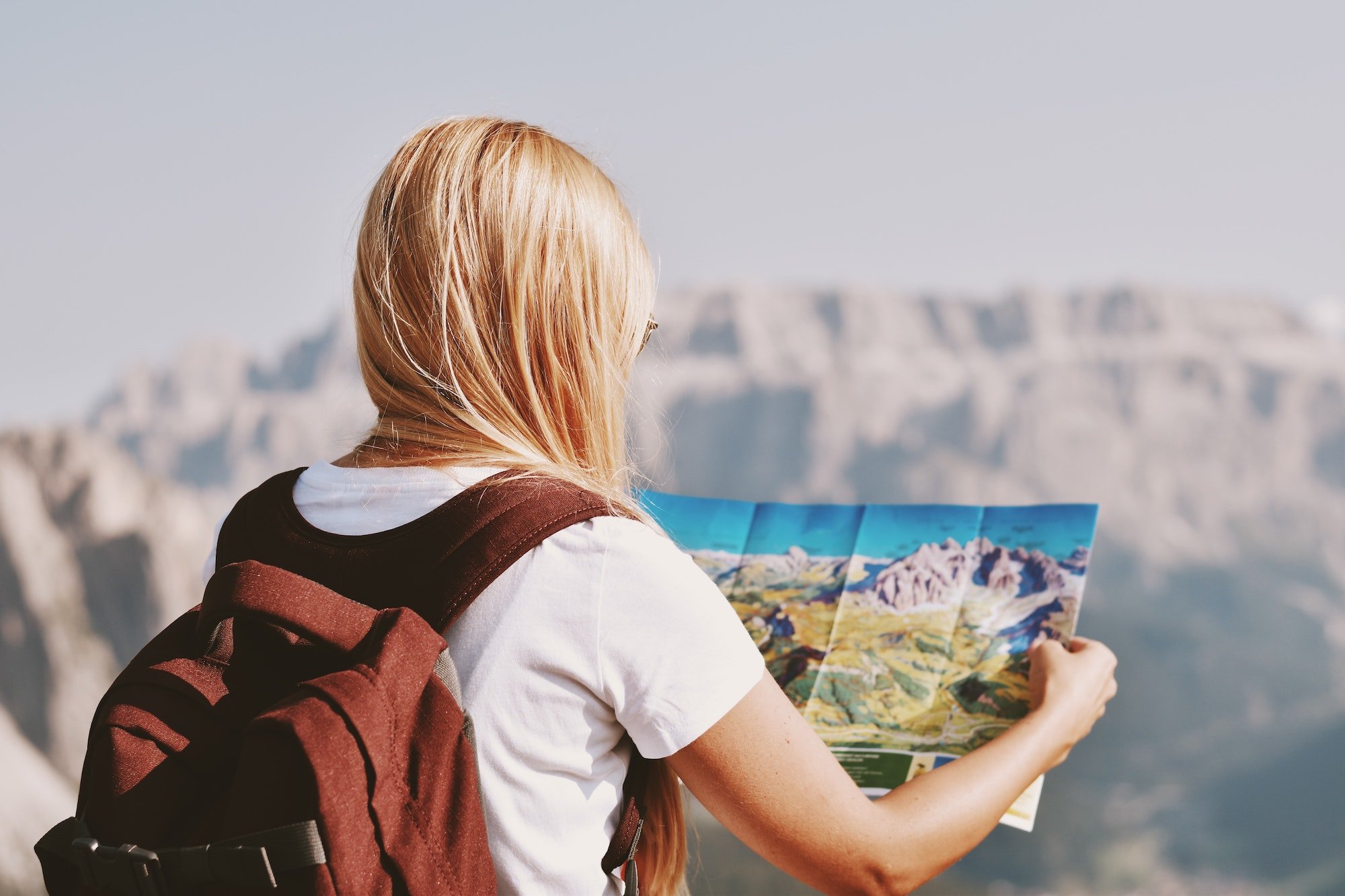 Female hiker holding hiking map to learn to tame