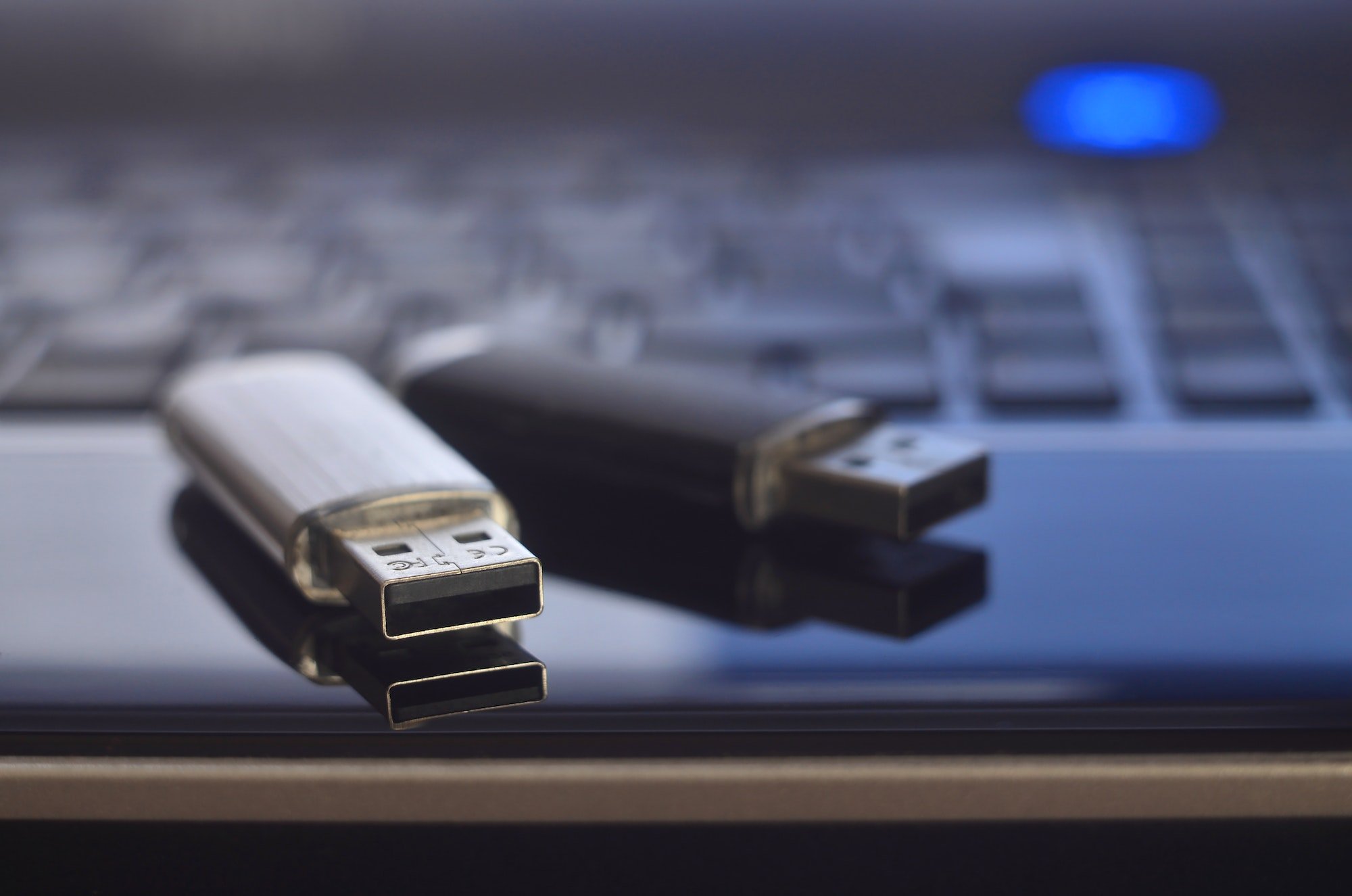 USB flash cards lying on black laptop case in front of his keyboard
